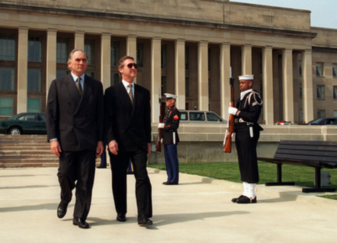 Secretary of Defense William S. Cohen (right), escorts Minister of State for Defense Charles Millon (left), of the French Republic, to the Pentagon River Parade Field. Cohen hosted an armed forces full honors arrival ceremony welcoming Millon on March 25, 1997. 