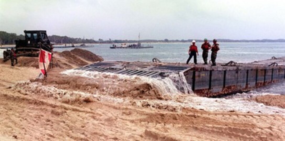 Seabees from the U.S. Navy's 1st Amphibious Construction Battalion hit the mark on Feb. 23, 1997, after days of bad weather delayed the inserting of a portable floating pier at Freshwater Beach, Rockhampton, Australia. The Seabees are participating in exercise Tandem Thrust '97, a combined military training exercise involving 28,000 personnel, 252 aircraft and 43 ships, and is designed to train U.S. and Australian staffs in crisis action planning and contingency response operations. 