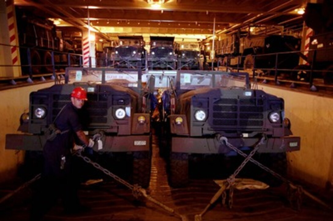 U.S. Marine Corps Lance Cpl. Rudy Quiroz releases a tie down chain in preparation for unloading a M-923 5-ton transport truck from the cargo deck inside the M.V. 1st Lt. Jack Lummus docked at Boyne Smelter Pier, Gladstone, Australia, on March 1, 1997. Nearly 140 vehicles are being unloaded from the Maritime Prepositioning Force ship for use in exercise Tandem Thrust '97. Tandem Thrust is a combined military training exercise involving 28,000 personnel, 252 aircraft and 43 ships, and is designed to train U.S. and Australian staffs in crisis action planning and contingency response operations. Quiroz is attached to the U.S. Marine Corps 3rd Support Battalion. 