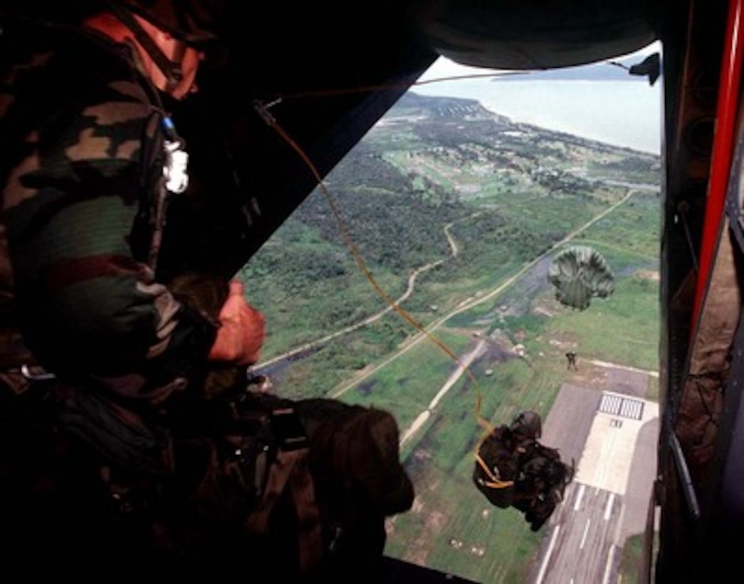 U.S. Army parachutists from the 1st Battalion, 1st Special Forces Group (Airborne) perform a static line jump out of an Australian DHC-4 Caribou troop transport aircraft over Royal Australian Air Force Base Townsville, Australia, on March 3, 1997. The soldiers are participating in exercise Tandem Thrust '97, a combined military training exercise involving 28,000 personnel, 252 aircraft and 43 ships, and is designed to train U.S. and Australian staffs in crisis action planning and contingency response operations. The 1st Special Forces Group is deployed for the exercise from Okinawa, Japan. 