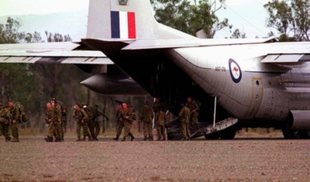 Members of the Australian 107th Battery, 4th Field Regiment, walk out of an Australian C-130 Hercules at Williamson Airfield, Queensland, on March 10, 1997, for exercise Tandem Thrust '97. Tandem Thrust is a combined military training exercise involving 28,000 personnel, 252 aircraft and 43 ships, and is designed to train U.S. and Australian staffs in crisis action planning and contingency response operations. The 107th Battery is deployed for the exercise from Townsville, Australia. 