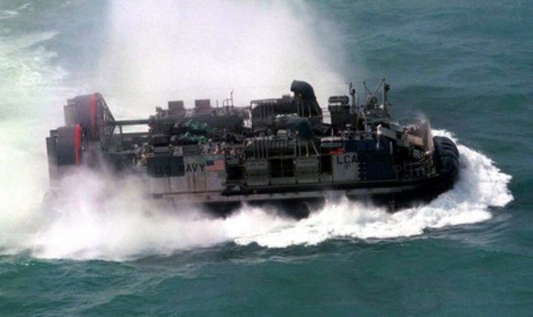 A U.S. Navy Landing Craft Air Cushion, or LCAC as it is more commonly called, hustles a cargo of Marine equipment from amphibious ships to the beach head at Freshwater Beach, Rockhampton, Australia, during exercise Tandem Thrust '97 on March 15, 1997. Tandem Thrust is a combined military training exercise involving 28,000 personnel, 252 aircraft and 43 ships, and is designed to train U.S. and Australian staffs in crisis action planning and contingency response operations. 