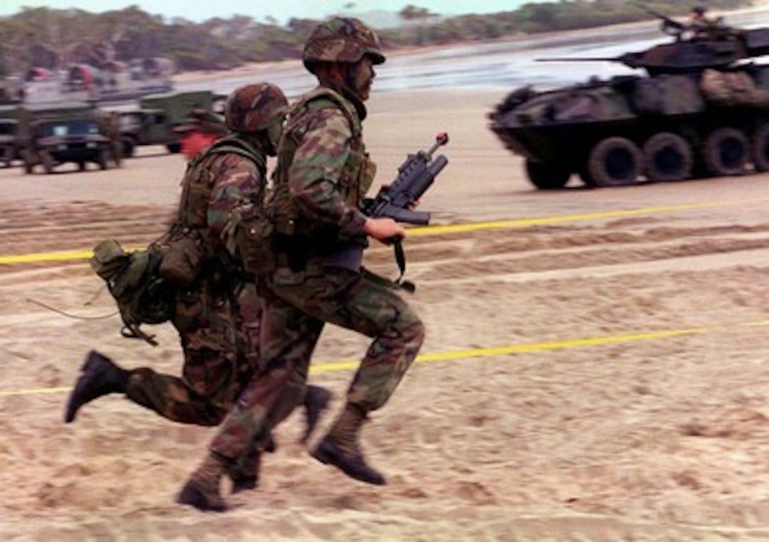 U.S. Marines race down the beach at Freshwater Beach, Rockhampton, Australia, during exercise Tandem Thrust '97 on March 16, 1997. Tandem Thrust is a combined military training exercise involving 28,000 personnel, 252 aircraft and 43 ships, and is designed to train U.S. and Australian staffs in crisis action planning and contingency response operations. 