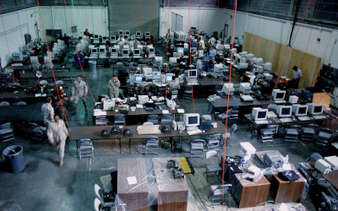 The Air Operations Center at Fort Bliss, Texas, comes alive as Air Force and civilian computer specialists prepare for Exercise Roving Sands 97 on April, 9, 1997. More than 20,000 service members from all branches of the armed forces of the U.S., Canada, Germany, and the Netherlands are participating in Exercise Roving Sands 97. The exercise is designed to refine their skills in operations using an integrated air defense network of ground, missile and radar early warning systems combined with tactical fighter and bomber aircraft operating in a simulated high-threat environment. The Air Operations Center will manage, control and organize air assets throughout the Roving Sands arena. 