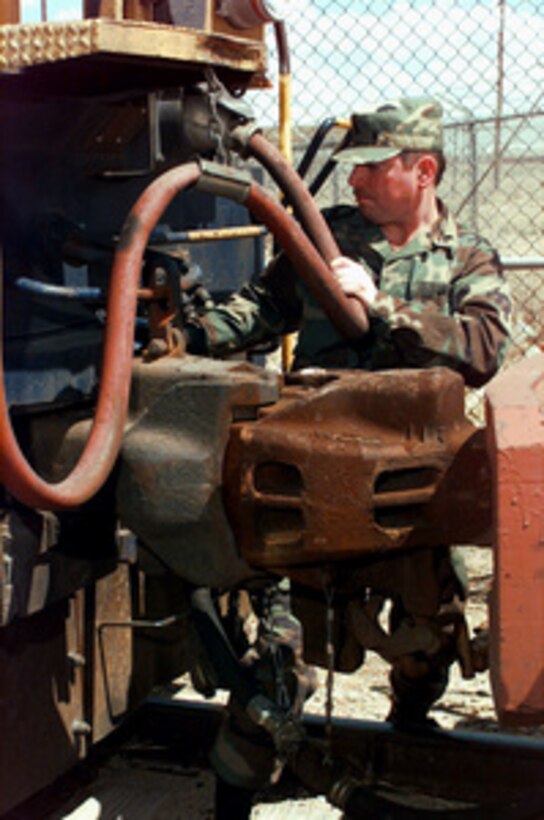 U.S. Army Sgt. Michael Czarnecki checks the coupling and hoses of a locomotive at Roswell, N.M., before the train pulls away from the siding on April 10, 1997. The train unloaded vehicles which will be used by the Netherlands Army in Exercise Roving Sands 97. More than 20,000 service members from all branches of the armed forces of the U.S., Canada, Germany, and the Netherlands are participating in Exercise Roving Sands 97. The exercise is designed to refine their skills in operations using an integrated air defense network of ground, missile and radar early warning systems combined with tactical fighter and bomber aircraft operating in a simulated high-threat environment. Czarnecki is a train conductor from the 1150th Transportation Company, Milwaukee, Wis. 