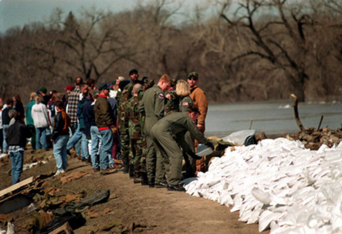 U.S. Air Force personnel pile sandbags as citizens of the Grand Forks N.D., community build a dike to hold back the rising Red River on April 17, 1997. Members of the 911th Air Refueling Squadron stationed at nearby Grand Forks Air Force Base are joining their community in the fight against the flood waters. 