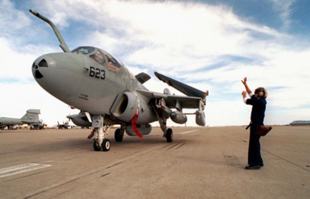 Airman Wallace Holden directs the pilot of this U.S. Navy EA-6B Prowler to the parking ramp area at Roswell, N.M. on April 18, 1997, during exercise Roving Sands 97. More than 20,000 service members from all branches of the armed forces of the U.S., Canada, Germany, and the Netherlands are participating in Exercise Roving Sands 97. The exercise is designed to refine their skills in operations using an integrated air defense network of ground, missile and radar early warning systems combined with tactical fighter and bomber aircraft operating in a simulated high-threat environment. Holden is deployed for the exercise from Tactical Electronic Warfare Squadron 132, of Naval Air Station Whidbey Island, Wash. 