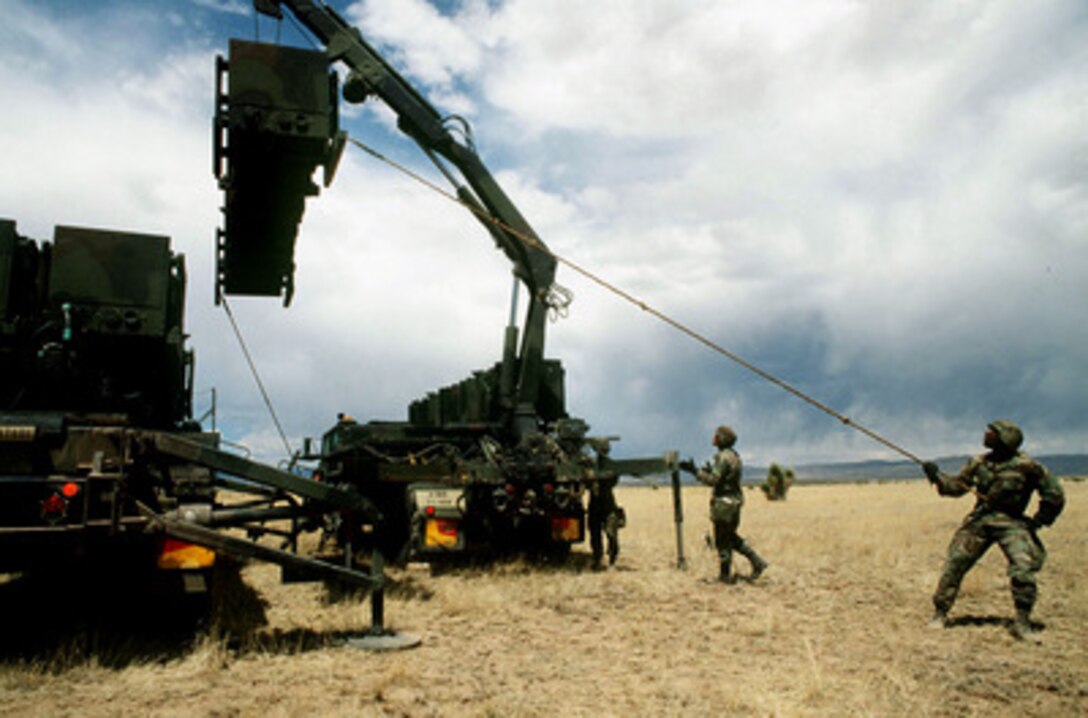 Soldiers from the 31st Air Defense Artillery Brigade load a Patriot missile onto a transfer vehicle at McGregor Test Range, N.M., during Exercise Roving Sands 97 on April 18, 1997. More than 20,000 service members from all branches of the armed forces of the U.S., Canada, Germany, and the Netherlands are participating in Exercise Roving Sands 97. The exercise is designed to refine their skills in operations using an integrated air defense network of ground, missile and radar early warning systems combined with tactical fighter and bomber aircraft operating in a simulated high-threat environment. The Patriot, used for land-to-air defense, and the soldiers are deployed from Alpha Battery, 1st Regiment, 1st Battalion, Fort Bliss, Texas. 