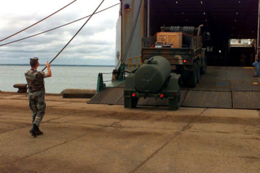 A Marine guides the driver of an M-923A2 5-ton truck and its trailer as he backs off the M.V. Villars at the port facility in Paldiski, Estonia, on July 10, 1997, for Exercise Baltic Challenge 97. Baltic Challenge '97 is a multinational exercise conducted as a NATO Partnership for Peace initiative involving more than 2,600 military personnel from Denmark, Estonia, Finland, Latvia, Lithuania, Norway, Sweden, and the U.S. The focus of the training is peacekeeping tasks and humanitarian assistance operations. The Villars is bringing in equipment stored in Norway, as part of the Norway Air-Landed Marine Expeditionary Brigade Prepositioning Program. 