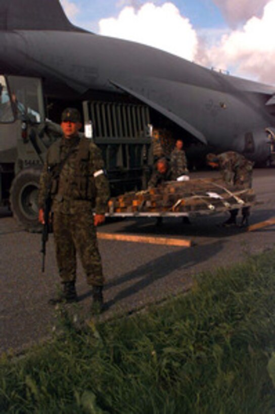 An Estonian soldier provides security while a U.S. Air Force C-5A Galaxy unloads 44 Marines and 29 pallets of their equipment at the airport in Tallinn, Estonia, on July 11, 1997, for Exercise Baltic Challenge 97. Baltic Challenge '97 is a multinational exercise conducted as a NATO Partnership for Peace initiative involving more than 2,600 military personnel from Denmark, Estonia, Finland, Latvia, Lithuania, Norway, Sweden, and the U.S. The focus of the training is peacekeeping tasks and humanitarian assistance operations. 