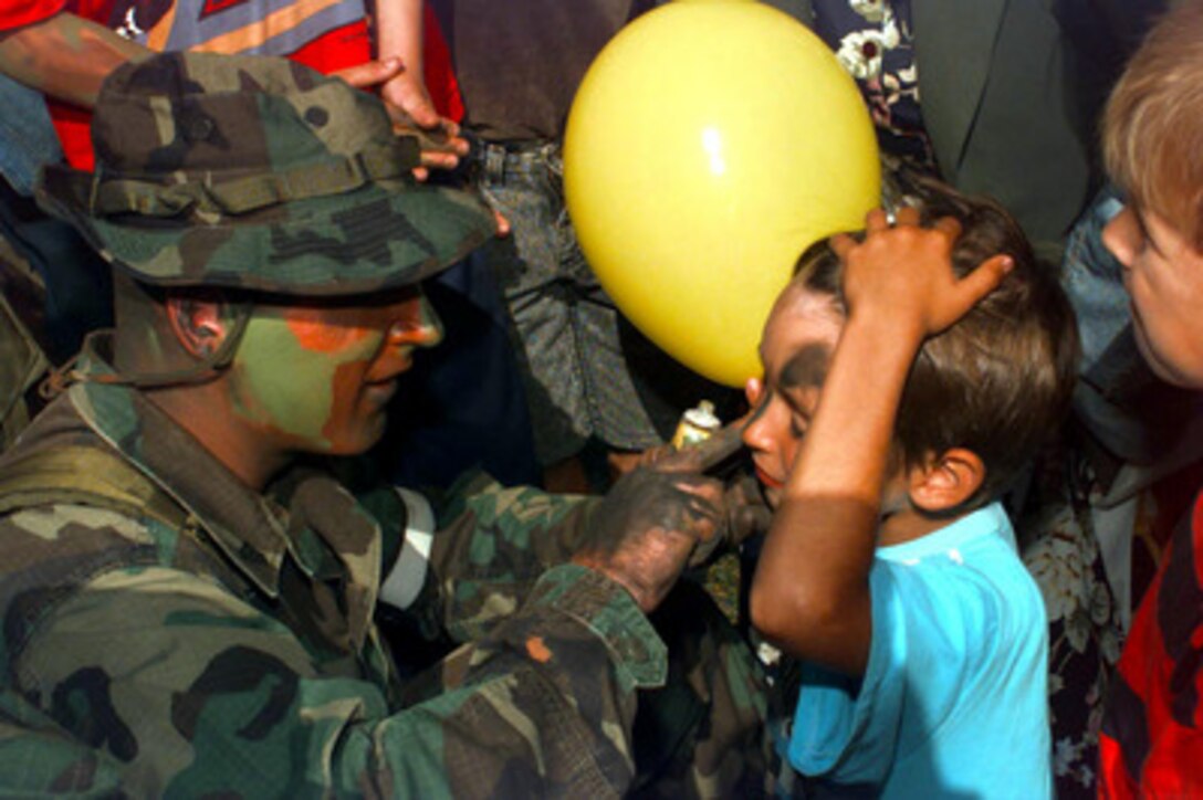 Cpl. O'Donaghue cammies up a face of a young Estonian boy during a picnic hosted for the citizens of Paldiski, Estonia, on July 13, 1997. O'Donaghue is deployed to Estonia for Exercise Baltic Challenge 97. Baltic Challenge '97 is a multinational exercise conducted as a NATO Partnership for Peace initiative involving more than 2,600 military personnel from Denmark, Estonia, Finland, Latvia, Lithuania, Norway, Sweden, and the U.S. The focus of the training is peacekeeping tasks and humanitarian assistance operations. O'Donaghue is from Bravo Company, 1st Battalion, 25th Marines. 