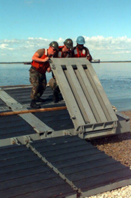 Sailors from Beachmaster Unit 2 flip over one of the ramps of a lighter craft in preparation for unloading equipment brought ashore near Paldiski, Estonia, from the S.S. Sgt. Matej Kocak during Exercise Baltic Challenge 97, on July 14, 1997. Baltic Challenge '97 is a multinational exercise conducted as a NATO Partnership for Peace initiative involving more than 2,600 military personnel from Denmark, Estonia, Finland, Latvia, Lithuania, Norway, Sweden, and the U.S. The focus of the training is peacekeeping tasks and humanitarian assistance operations. The lighter craft are being used to move equipment off-loaded from the Maritime Prepositioning Ships anchored off shore to the exercise area on the beach. Beachmaster Unit 2 is homeported in Little Creek, Va. 