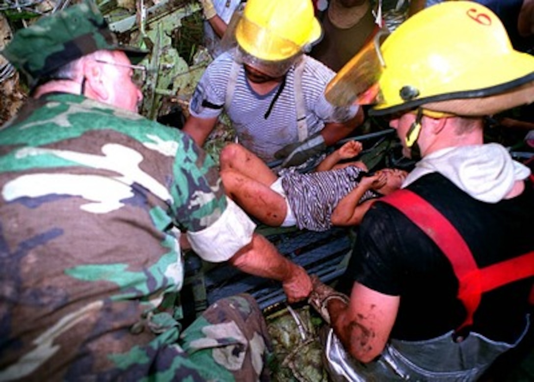 A young survivor is gently extracted from the wreckage of Korean Airlines flight 801 by U.S. Navy, U.S. Air Force, and Guam civilian rescuers.   U.S. Navy, U.S. Air Force and numerous civilian rescue teams, currently assisting in the search and rescue efforts of KAL flight 801, evacuated survivors from the crash site during the early morning of August 6th (local). 