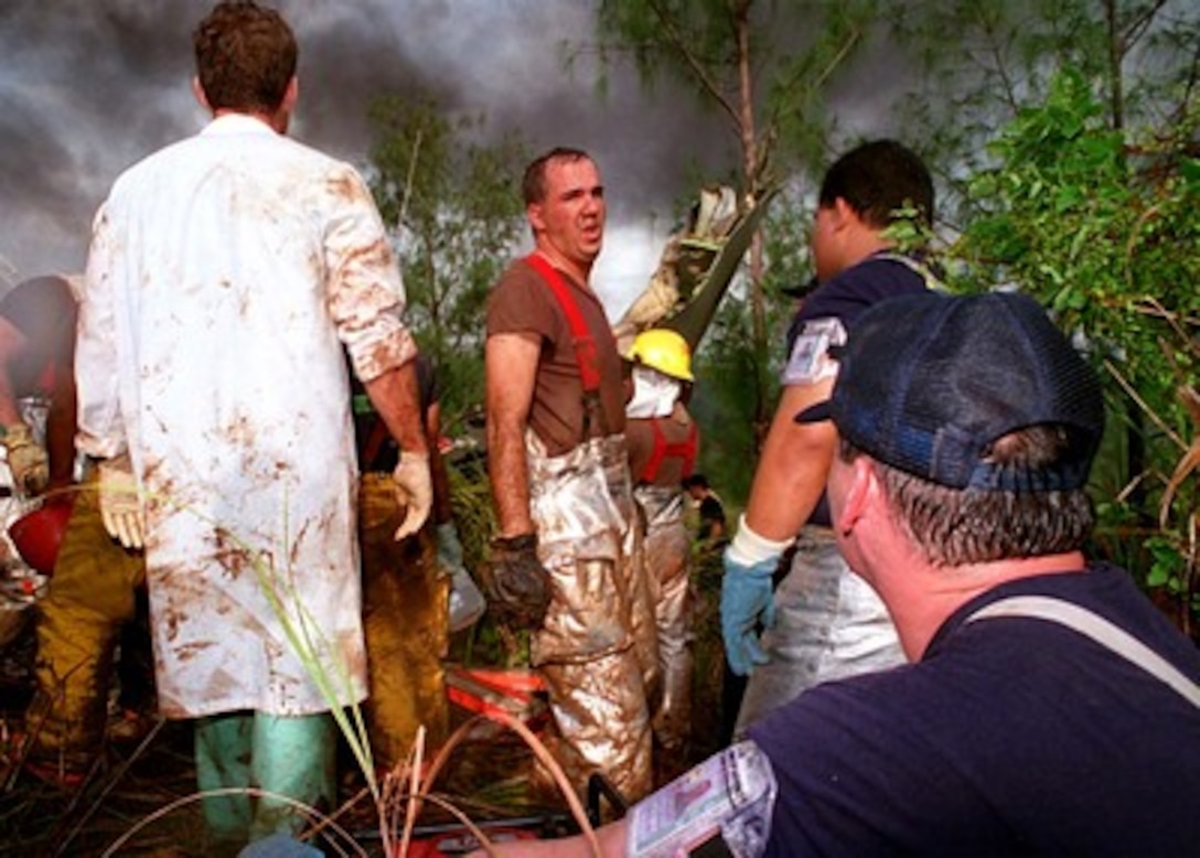 Exhausted rescuers take a break during emergency operations in response to the crash of Korean Airlines flight 801 Aug. 6, 1997.  U.S. Navy, U.S. Coast Guard, U.S. Air Force, and numerous civilian rescue teams, currently assisting in the search and rescue efforts of KAL flight 801, evacuated survivors from the crash site during the early morning of August 6th. 