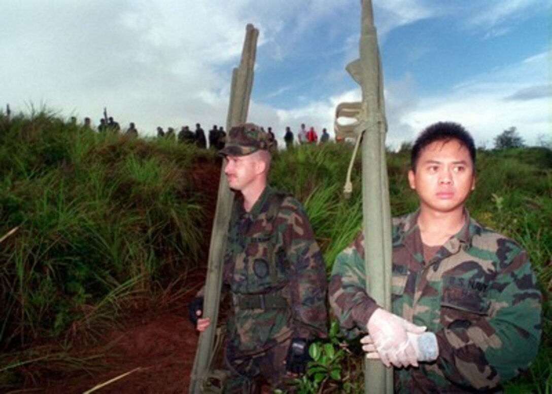 U. S. Navy Auxiliary Security Force members stand by to assist in rescue efforts in response to the crash of Korean Airlines flight 801 on Aug 6, 1997.  U.S. Navy, U.S. Coast Guard, U.S. Air Force, and numerous civilian rescue teams, currently assisting in the search and rescue efforts of KAL flight 801, evacuated survivors from the crash site during the early morning of August 6th. 