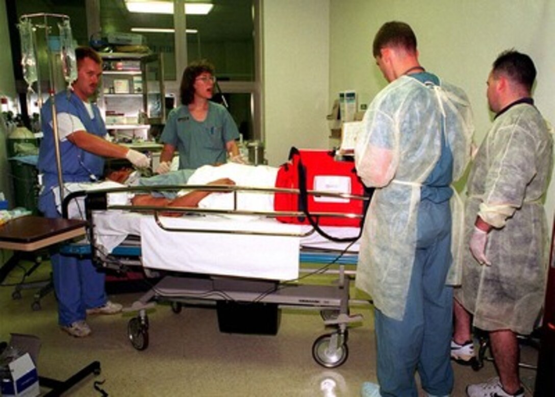 Navy medical personnel treat a survivor of Korean Airlines flight 801 at U.S. Naval Hospital, Guam, on Aug. 6, 1997.   U.S. Navy, U.S. Coast Guard, U.S. Air Force, and numerous civilian rescue teams, currently assisting in the search and rescue efforts of KAL flight 801, evacuated survivors from the crash site during the early morning of August 6th. 