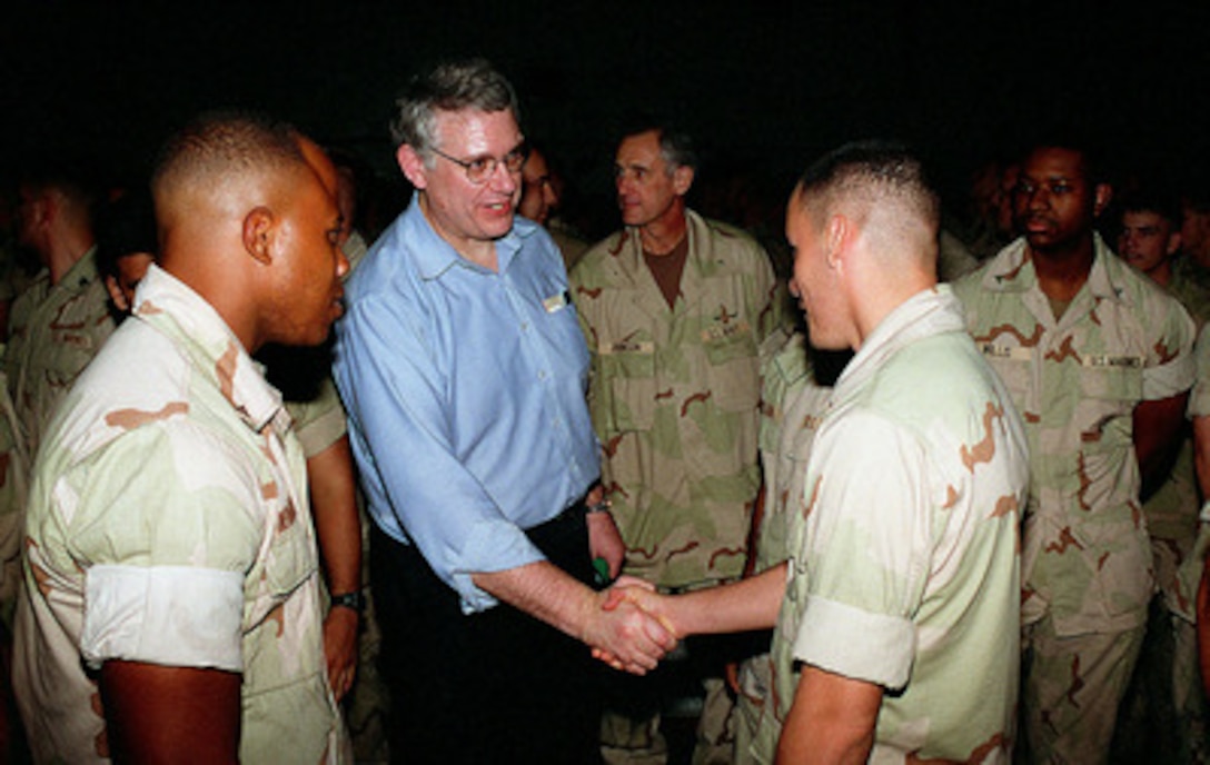 Deputy Secretary of Defense John J. Hamre (center) greets sailors and Marines while aboard the amphibious assault ship USS Peleliu (LHA 5) on Nov. 28, 1997. Hamre is making the Thanksgiving holiday visit to personally thank U.S. sailors and Marines for their commitment to serving their country and for helping to ensure peace and stability in the Persian Gulf region. USS Peleliu is part of the Amphibious Ready Group deployed in the Persian Gulf in support of Operation Southern Watch which is the U.S. and coalition enforcement of the no-fly-zone over Southern Iraq. Peleliu carries 2,100 combat ready U.S. Marines, helicopters, landing craft, and vertical launch aircraft like the AV-8B Harrier fighter-attack aircraft. 