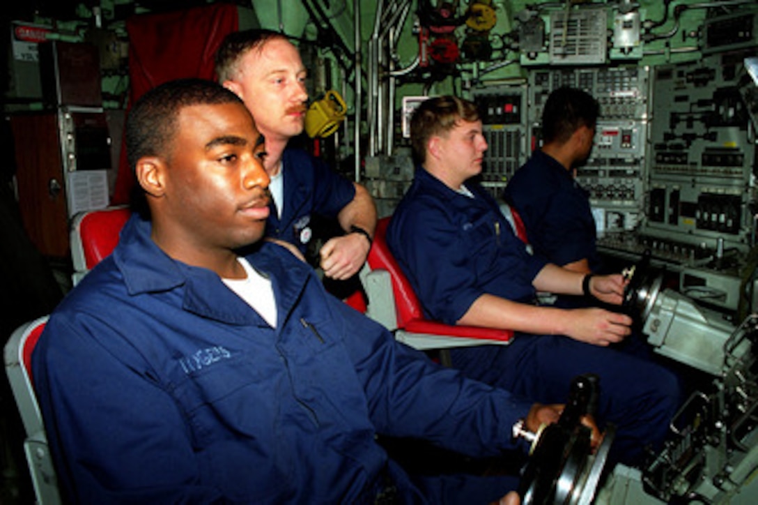 Helmsman of the Watch Fireman Apprentice Darrell Rogers (left), Diving Officer of the Watch Chief Petty Officer Scott Fletcher (center), and Planesman of the Watch Petty Officer 3rd Class Rocky Bolin (center right), maneuver the fast attack submarine USS Annapolis (SSN 760) in the waters of the Persian Gulf on Nov. 29, 1997. The nuclear powered submarine is operating in the Persian Gulf as part of the USS George Washington (CVN 73) battle group in support of Operation Southern Watch which is the U.S. and coalition enforcement of the no-fly-zone over Southern Iraq. Rogers is from Birmingham, Ala., Fletcher is a Navy machinist's mate from Lyons, N.Y., and Bolin is a Navy yeoman from Russell Springs, Ky. 