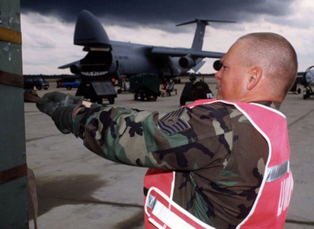 Tech. Sgt. Darrell Hodger tightens down a cargo strap on a pallet of equipment so it can be loaded on a C-5A Galaxy aircraft at Shaw Air Force Base, S.C., for shipment to the Persian Gulf area of operations on Nov. 21, 1997. The equipment will be used to support the 347th Air Expeditionary Wing (Provisional), from Moody Air Force Base, Ga., in Operation Southern Watch. Southern Watch is the U.S. and coalition enforcement of the no-fly-zone over Southern Iraq. Hodger is a load team member of the 20th Equipment Maintenance Squadron at Shaw. 