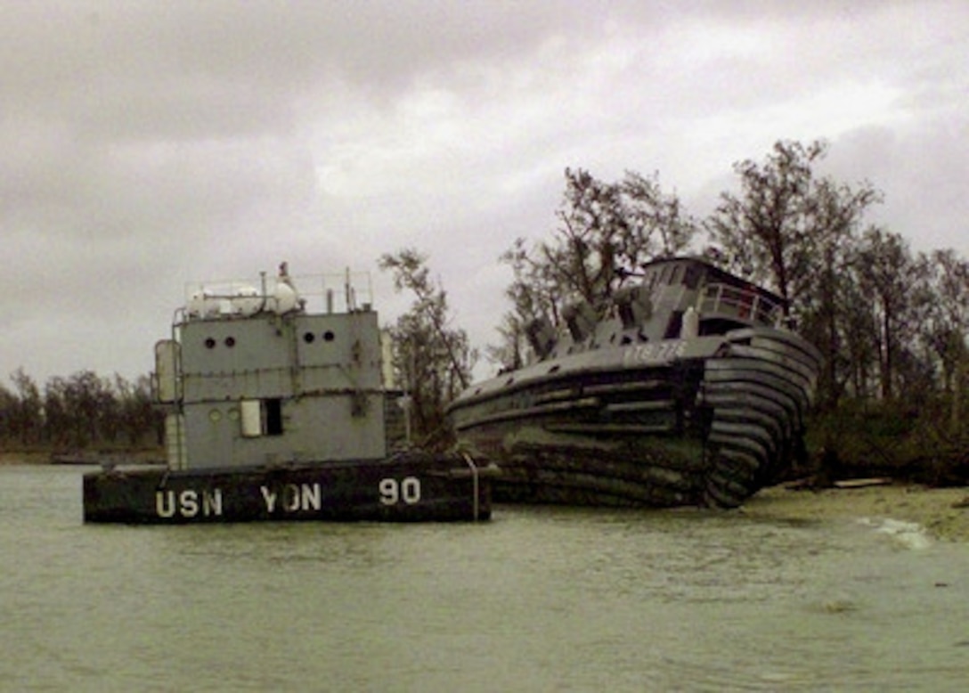 A U.S. Navy barge and tug boat lie where they were beached by super typhoon Paka at Naval Station Marianas, Guam, on Dec. 17, 1997. Super typhoon Paka hit the island the night before with average sustained winds of 175 mph. One wind gust recorded at nearby Anderson Air Force Base was the strongest ever recorded on earth at 236 mph. 