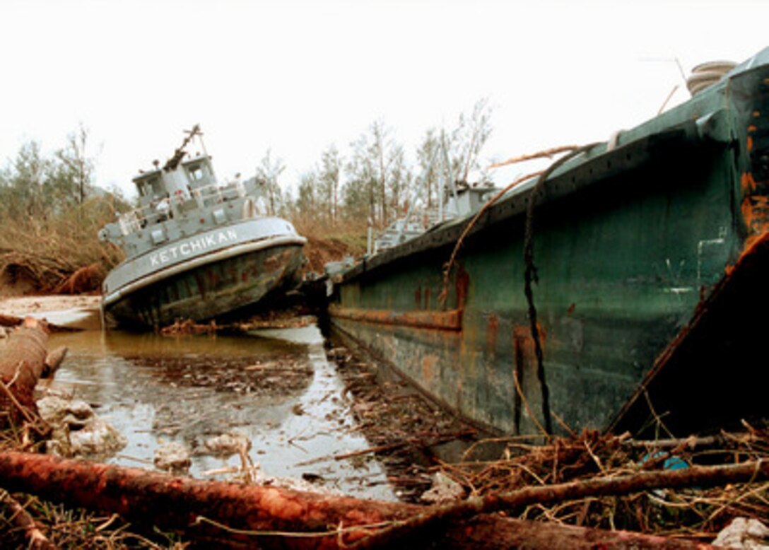 The U.S. Navy tug Ketchikan and a barge lie where they were beached by super typhoon Paka at Naval Station Marianas, Guam, on Dec. 17, 1997. Super typhoon Paka hit the island the night before with average sustained winds of 175 mph. One wind gust recorded at nearby Anderson Air Force Base was the strongest ever recorded on earth at 236 mph. 