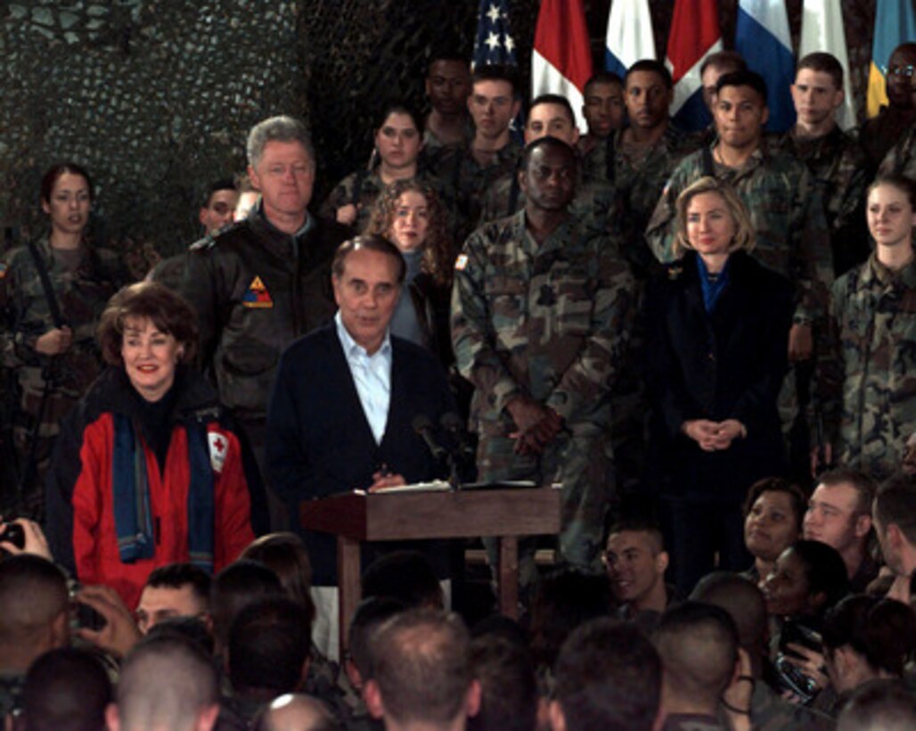 Former Senator Bob Dole talks to Task Force Eagle soldiers at the 21 Club, Eagle Base, Tuzla, Bosnia and Herzegovina, on Dec. 22, 1997. Dole and his wife Elizabeth (left) accompanied President Bill Clinton, his wife Hillary and their daughter Chelsea for a holiday visit with the troops in Bosnia and Herzegovina. 