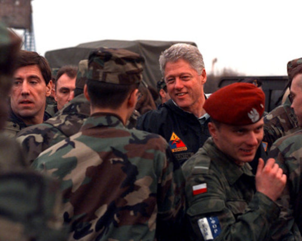 President Bill Clinton shakes hands with soldiers at the Tuzla Air Field, Bosnia and Herzegovina, on Dec. 22, 1997. The president was accompanied by his wife Hillary, their daughter Chelsea, former Senator Bob Dole and his wife Elizabeth, for the holiday visit with the troops in Tuzla. 