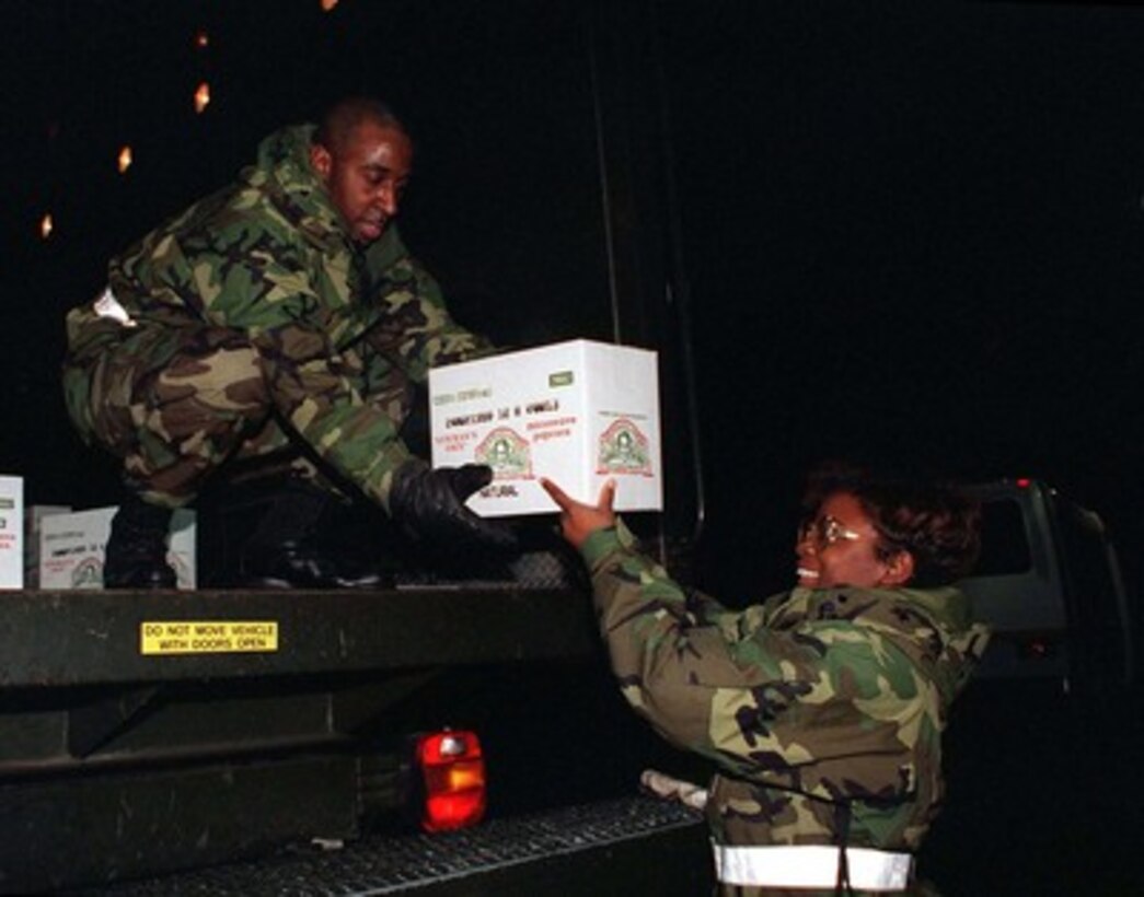 U.S. Air Force Staff Sgts. Clint Harvin (left) and Twyla Thompson load a truck at Andrews Air Force Base, Md., with one of the 160 cases of Newman's Own microwave popcorn bound for soldiers in Bosnia and Herzegovina on Dec. 23, 1997. Actor and popcorn magnate Paul Newman donated the 5,760 bags of the popcorn which will be transported by Secretary of Defense William S. Cohen on his aircraft as he makes a holiday visit to the troops in Bosnia and Herzegovina. Harvin and Thompson are attached to the 89th Aerial Port Squadron at Andrews. 