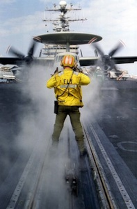 Petty Officer 3rd Class Kevin P. Spurrell directs an E-2C Hawkeye onto one of the bow catapults during launch preparations on the flight deck of the aircraft carrier USS Nimitz (CVN 68) on Dec. 24, 1997. The Nimitz and embarked Carrier Air Wing 9 are operating in the Persian Gulf in support of the U.S. and coalition enforcement of the no-fly-zone over Southern Iraq. Spurrell is a Navy aviation boatswain's mate from Duncanville, Texas. 