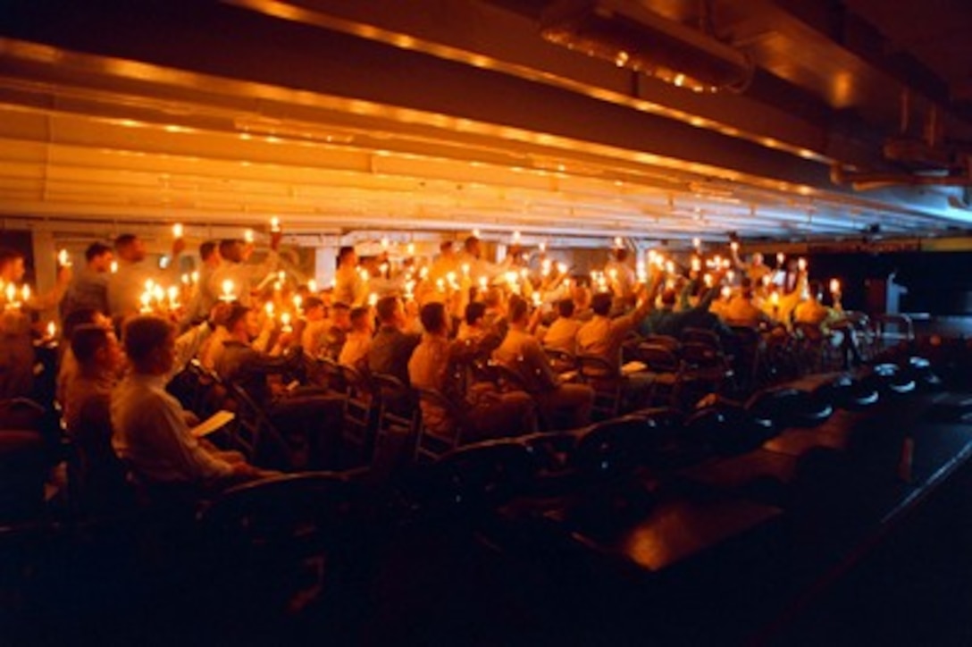 Sailors onboard the aircraft carrier USS George Washington (CVN 73) celebrate a candle light religious service in the Persian Gulf on Dec. 25 1997. Washington and her embarked Carrier Air Wing One are operating in the Persian Gulf in support of Operation Southern Watch which is the U.S. and coalition enforcement of the no-fly-zone over Southern Iraq. 