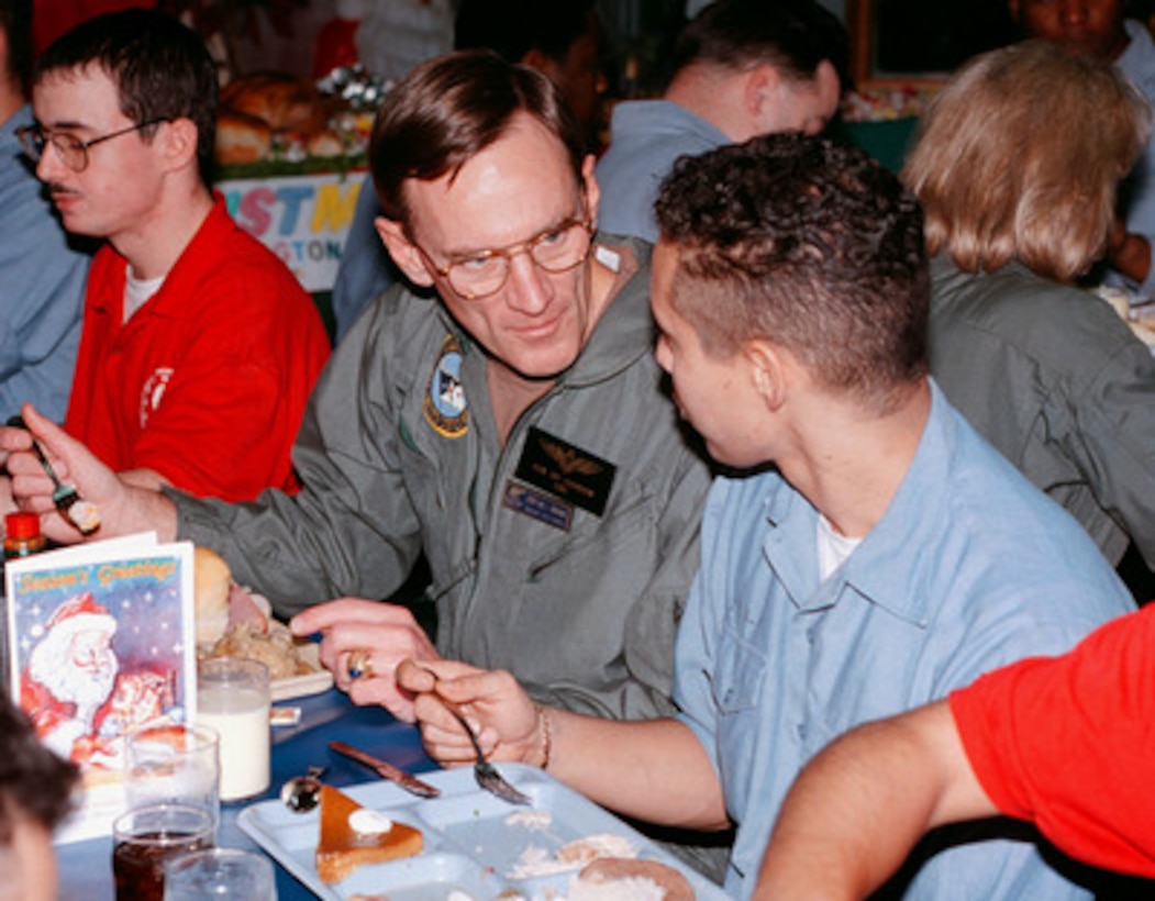 U.S. Navy Chief of Naval Operations Admiral Jay L. Johnson (center) talks with Airman Alan Milan (right), from Ft. Lauderdale, Fla., during Christmas dinner onboard the aircraft carrier USS George Washington (CVN 73) in the Persian Gulf on Dec. 25 1997. Washington and her embarked Carrier Air Wing One are operating in the Persian Gulf in support of Operation Southern Watch which is the U.S. and coalition enforcement of the no-fly-zone over Southern Iraq. Johnson is visiting sailors in the Persian Gulf region during the Christmas holidays. 