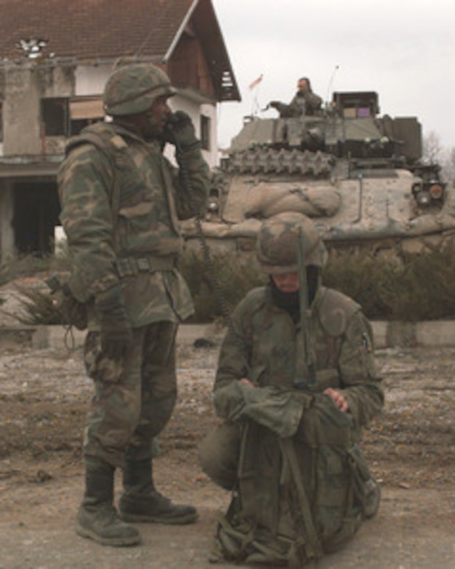 A U.S. Army soldier communicates with his headquarters as another soldier monitors the radio while on a security patrol near the town of Sljoke, Bosnia and Herzegovina, on Jan. 16, 1996, during Operation Joint Endeavor. The soldiers are patrolling the area in a M3-A2 Bradley Fighting Vehicle as part of the NATO Implementation Force (IFOR). The troops are deployed from the 1st Cavalry, Budingen, Germany. 