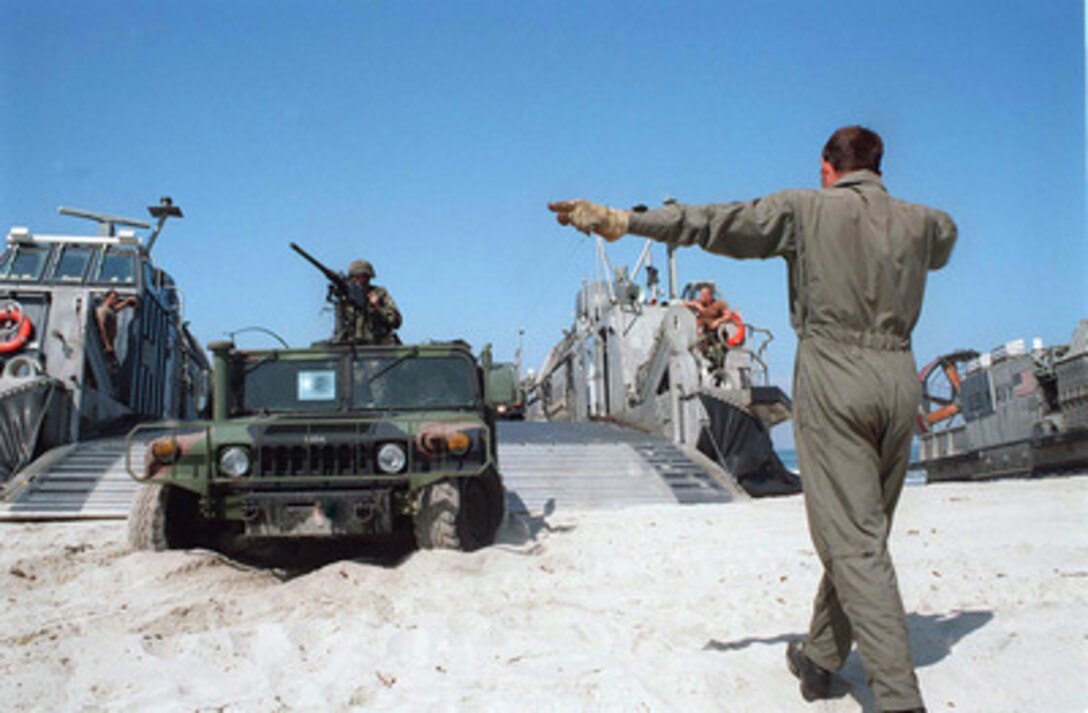 A Humvee from Regimental Landing Team One, 1st Marine Division is directed down Red Beach during the amphibious assault of Exercise Kernel Blitz 97 at Camp Pendleton, Calif., on June 28, 1997. Kernel Blitz 97 is a major amphibious exercise taking place in Southern California and waters offshore. More than 12,000 sailors, Marines, soldiers, guardsmen and airmen are involved in the exercise which is designed to test the Navy-Marine Corps team's ability to project combat power ashore. 