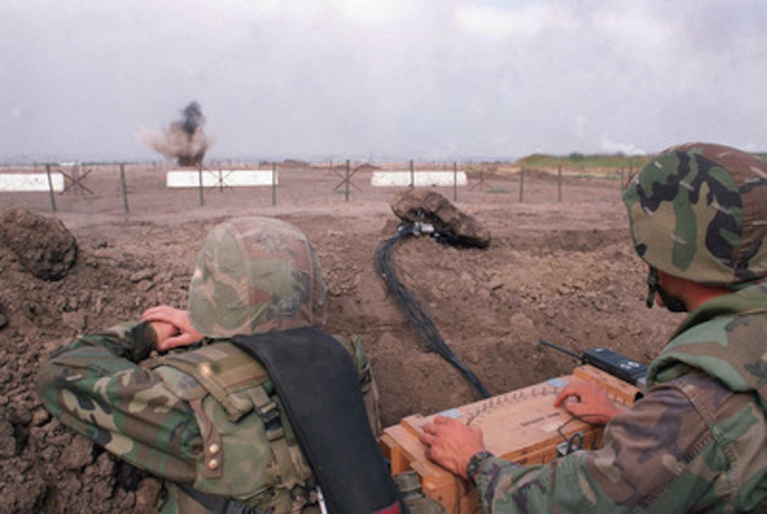 Two Marines from 1st Combat Engineer Battalion, 1st Marine Division, detonate demolitions on Red Beach at Camp Pendleton, Calif., during Exercise Kernel Blitz 97, on June 28, 1997. Kernel Blitz 97 is a major amphibious exercise taking place in Southern California and waters offshore. More than 12,000 sailors, Marines, soldiers, guardsmen and airmen are involved in the exercise which is designed to test the Navy-Marine Corps team's ability to project combat power ashore. 
