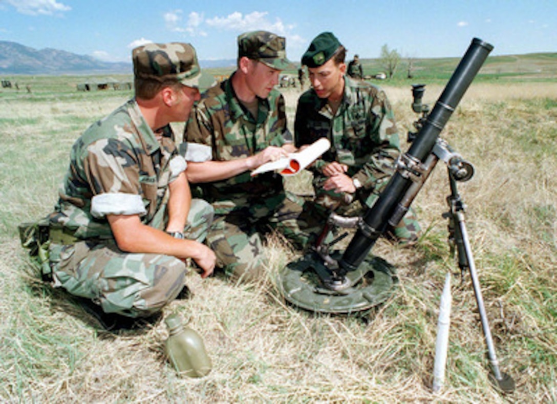 U.S. Army Sgt. 1st Class Jeff Keers (right) instructs U.S. Navy Seabees Petty Officers 3rd Class Jeff Peters (center) and John Kirkwood (left) on mortar tactics during Exercise Mountain Bee '97 at Fort Carson, Colo., on May 16, 1997. The exercise will give the reserve Seabees in-field training on the use of weapons, medical evacuations, communications, logistics and other combat related training. Keers is attached to the 3rd Battalion, 10th Special Forces Group. Peters and Kirkwood are attached to Naval Mobile Construction Battalion 17. 