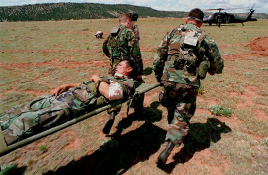 U.S. Navy Seabees from Naval Mobile Construction Battalion 17 carry an "injured" Seabee to an Army medevac helicopter during Exercise Mountain Bee '97 at Fort Carson, Colo., on May 17, 1997. The exercise will give the reserve Seabees in-field training on the use of weapons, medical evacuations, communications, logistics and other combat related training. 