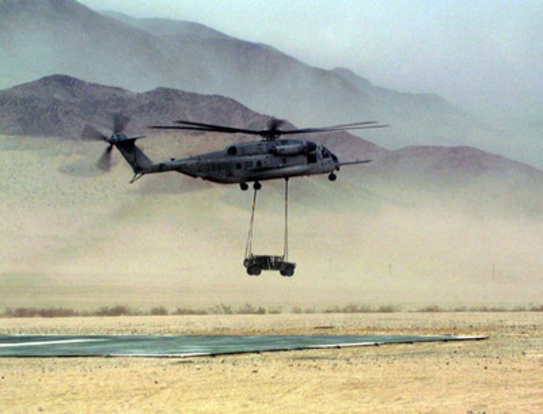 A CH-53E Super Stallion helicopter lowers a Humvee to the landing pad during Helicopter Support Team Training at the Marine Corps Air Ground Combat Center, Twentynine Palms, Calif., during Combined Arms Exercise 5-97, on May 17, 1997. The Marine Air Ground Task Force exercise is allowing these aviators from Marine Heavy Helicopter Squadron 461, Marine Corps Air Station New River, N.C., to practice their desert warfare. 