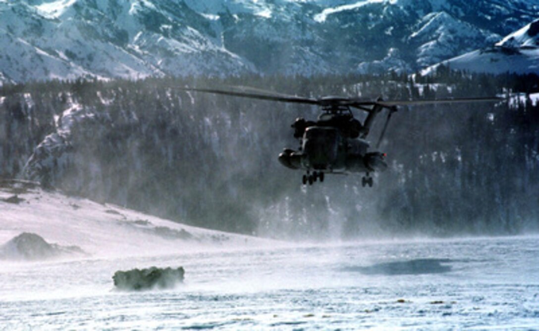 A U.S. Marine Corps CH-53E Super Stallion makes an approach to land and pick up a huddle of Marines at the Mountain Warfare Training Center, Bridgeport, Calif., on Feb. 15, 1997. Marines from the 2nd Marine Regiment and 3rd Battalion, 8th Marines of Camp Lejeune, N. C. are at the Center to train in cold weather survival and arctic warfare. 