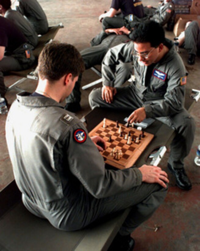 Airman 1st Class Mario Menizabal (right) and Capt. Ken Vaneyk pass the time between missions by playing chess at the Libreville International Airport, Republic of Gabon, on March 24, 1997. Command and support elements for a forward joint task force and other enabling elements are deploying to locations in several West African countries as part of contingency planning for a possible future evacuation from Zaire. The deployment is an enhancement to planning for contingency measures to ensure the security of U.S. citizens in Zaire if an evacuation should become necessary. Menizabal is a loadmaster and Vaneyk is a co-pilot of a C-141 Starlifter from the 4th Airlift Squadron, McChord Air Force Base, Wash. 