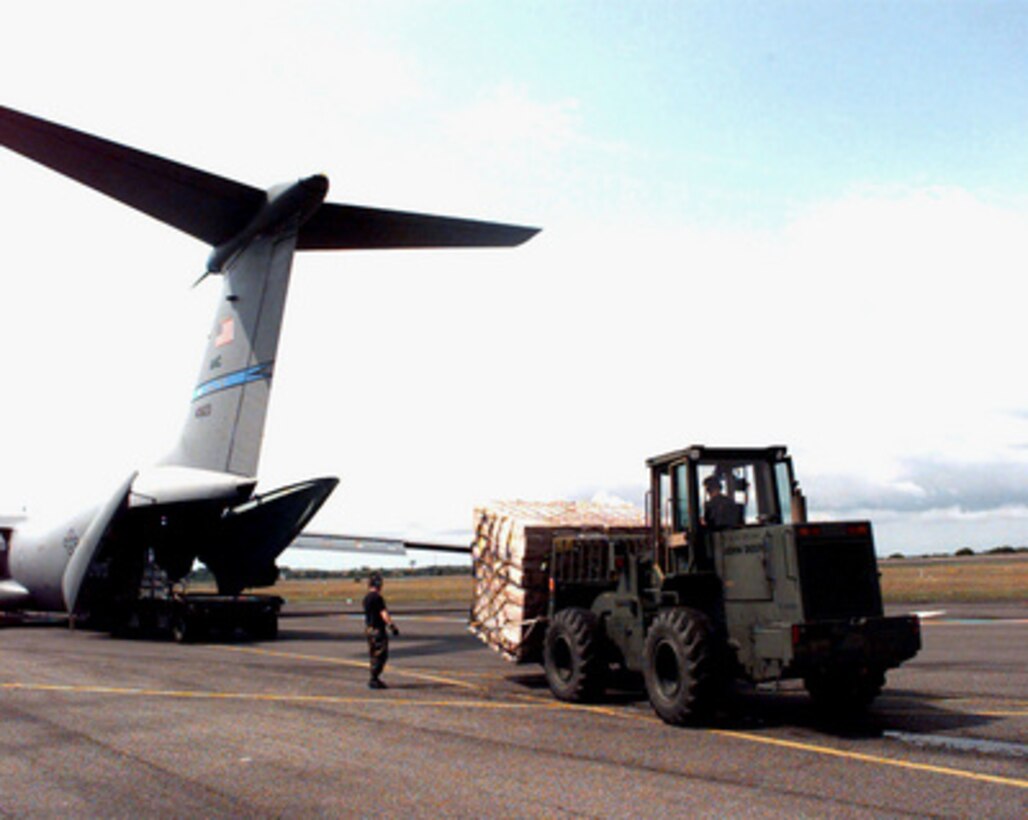 U.S. Air Force airmen use a K-loader and a forklift to unload cargo from a C-141 Starlifter on the ramp at the Libreville International Airport, Republic of Gabon, on March 24, 1997. Command and support elements for a forward joint task force and other enabling elements are deploying to locations in several West African countries as part of contingency planning for a possible future evacuation from Zaire. The deployment is an enhancement to planning for contingency measures to ensure the security of U.S. citizens in Zaire if an evacuation should become necessary. The aircraft is deployed from McChord Air Force Base, Wash. 