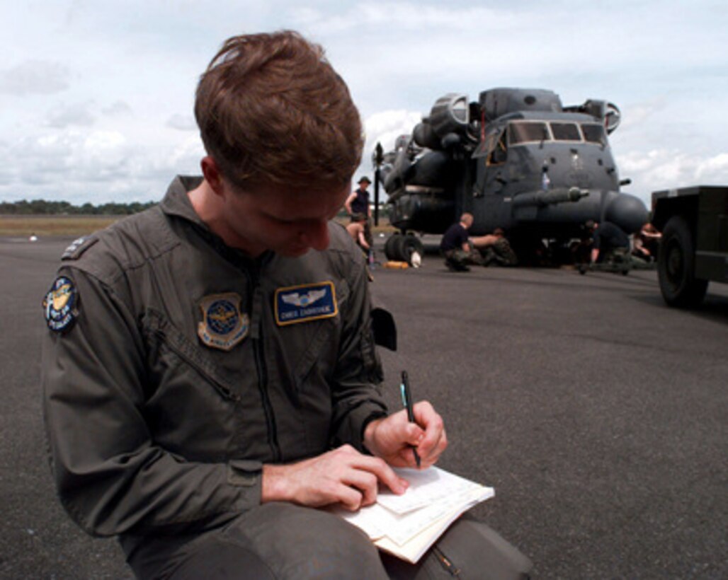 U.S. Air Force C-5 Galaxy co-pilot Capt. Chris Zabriskie fills out flight plans as a MH-53J Pave Low helicopter is unloaded at the Libreville International Airport, Republic of Gabon, on March 25, 1997. Command and support elements for a forward joint task force and other enabling elements are deploying to locations in several West African countries as part of contingency planning for a possible future evacuation from Zaire. The deployment is an enhancement to planning for contingency measures to ensure the security of U.S. citizens in Zaire if an evacuation should become necessary. The Pave Low and its crew are deployed from the 21st Special Operations Squadron, RAF Mildenhall, United Kingdom. The C-5 is from the 9th Airlift Squadron, Dover Air Force Base, Del. 