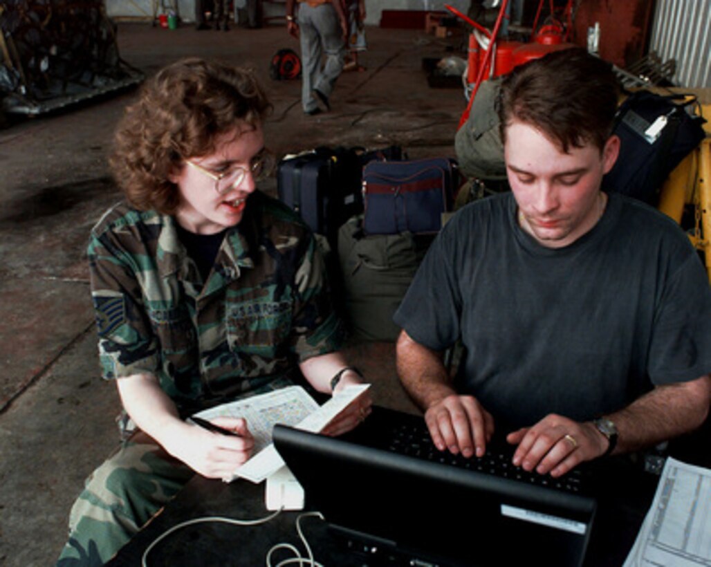Staff Sgt. Tammy Mcabee (left) and Senior Airman Scott Papineau use a laptop computer to process incoming personnel at the Libreville International Airport, Republic of Gabon, on March 25, 1997. Command and support elements for a forward joint task force and other enabling elements are deploying to locations in several West African countries as part of contingency planning for a possible future evacuation from Zaire. The deployment is an enhancement to planning for contingency measures to ensure the security of U.S. citizens in Zaire if an evacuation should become necessary. Mcabee is a personnel specialist with the 352nd Operations Support Squadron and Papineau is a personnel specialist with the 3rd Air Force both of RAF Mildenhall, United Kingdom. 