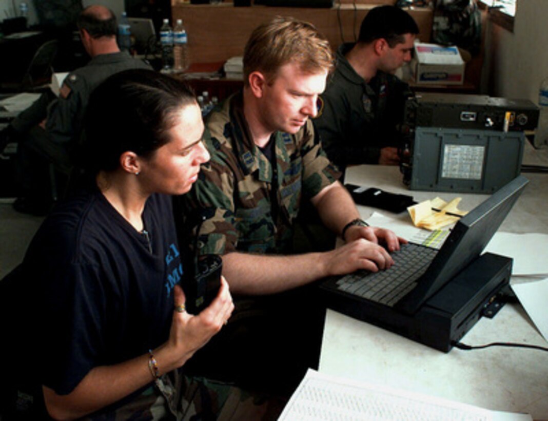 Airman 1st Class Carla Percy (left) listens to her hand held radio as Capt. John Groff uses a laptop computer to fill out airflow plans in a make shift office at the Libreville International Airport, Republic of Gabon, on March 26, 1997. Command and support elements for a forward joint task force and other enabling elements are deploying to locations in several West African countries as part of contingency planning for a possible future evacuation from Zaire. The deployment is an enhancement to planning for contingency measures to ensure the security of U.S. citizens in Zaire if an evacuation should become necessary. Percy and Groff are deployed from the 621st Air Mobility Control Squadron. 
