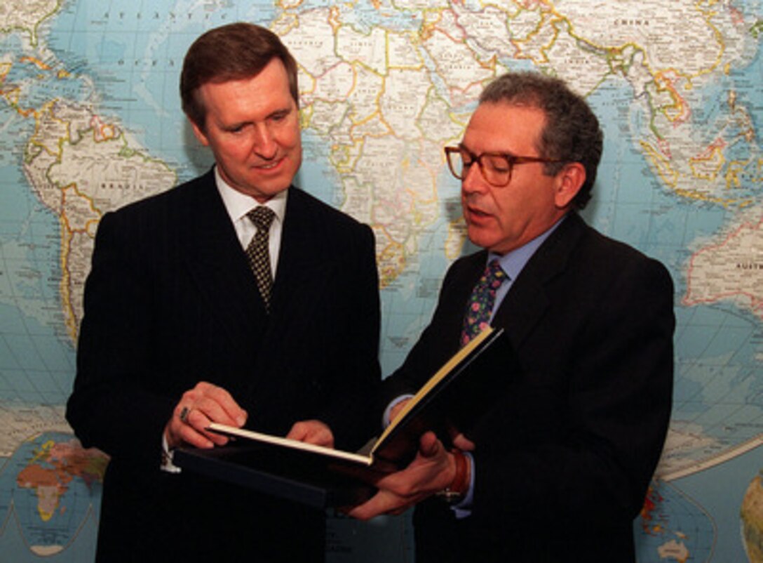 Minister of Defense Eduardo Serra (right), of the Kingdom of Spain, presents a gift to Secretary of Defense William S. Cohen (left), during his visit to the Pentagon on March 24, 1997. 