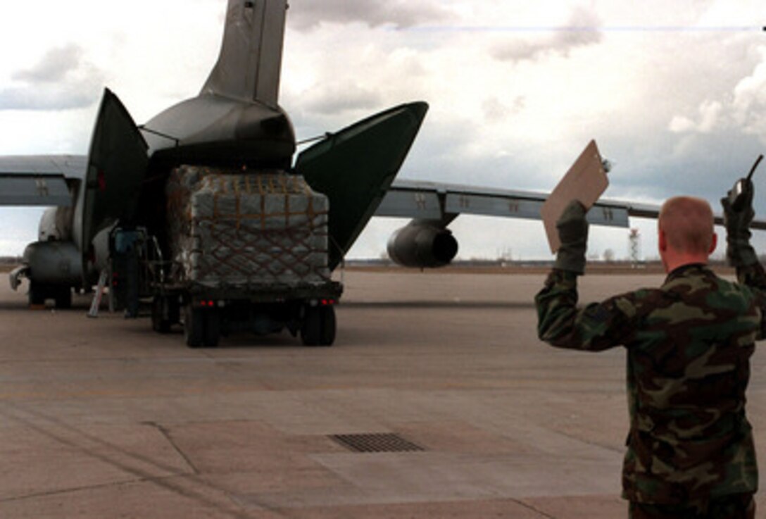 Staff Sgt. Jeff Pickens directs a k-loader back from a C-17 Globemaster III on the ramp at Grand Forks Air Force Base, N.D., on April 24, 1997. The Globemaster is bringing in a cargo of portable showers. The hangars at the air base are being used as temporary shelter for thousands of Grand Forks residents who were displaced by the flood waters of the Red River. Pickens is attached to the 319th Transportation Squadron at Grand Forks. The Globemaster is from the 8th Airlift Squadron at Mc Chord Air Force Base, Wash. 