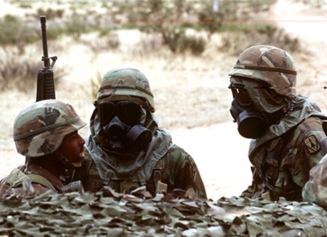 Staff Sgt. Nathaniel Williams (left) briefs Pvts. Ruben Gutierrez and Patrick O'Neal on their reaction to a simulated, aerial chemical attack against their camp during Exercise Roving Sands '97 on April 21, 1997. More than 20,000 service members from all branches of the armed forces of the U.S., Canada, Germany, and the Netherlands are participating in Exercise Roving Sands '97. The exercise is designed to refine their skills in operations using an integrated air defense network of ground, missile and radar early warning systems combined with tactical fighter and bomber aircraft operating in a simulated high-threat environment. The chemical attacks are being executed by former Russian helicopters operated by members of Optec Threat Support Activity, Biggs Army Airfield, Texas. 