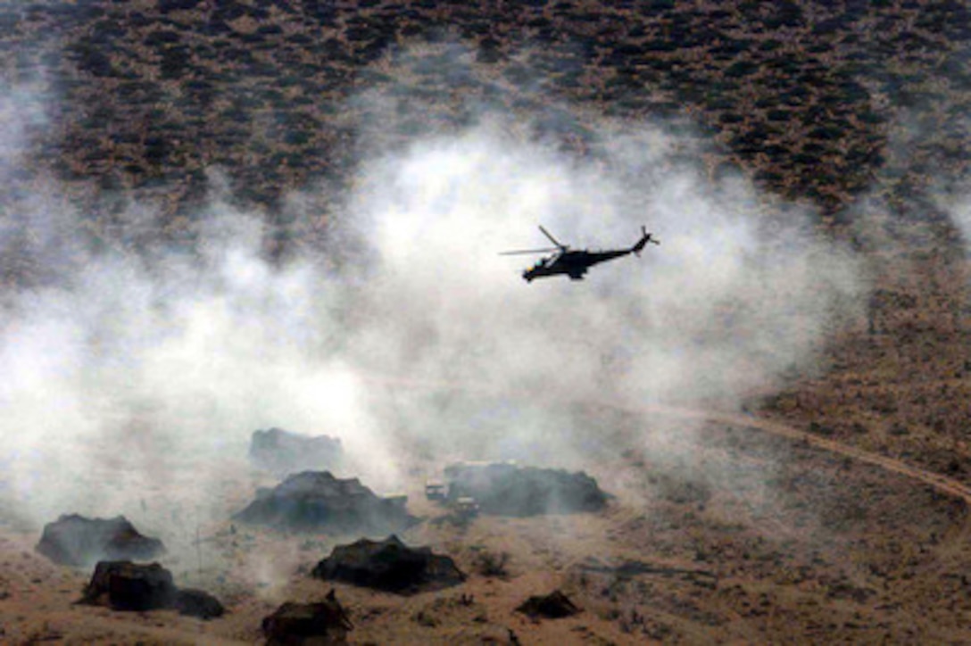 A MI-24 Hind attack helicopter simulates ground attacks as it flies in the mist of a simulated aerial chemical attack on an air defense site at Dona Ana Range, Fort Bliss, El Paso, Texas, on April 22, 1997. The attacks on the camp are part of Exercise Roving Sands '97. More than 20,000 service members from all branches of the armed forces of the U.S., Canada, Germany, and the Netherlands are participating in Roving Sands '97. The exercise is designed to refine their skills in operations using an integrated air defense network of ground, missile and radar early warning systems combined with tactical fighter and bomber aircraft operating in a simulated high-threat environment. The Russian made helicopter is operated by Optec Threat Support Activity, Biggs Army Airfield, Texas. 