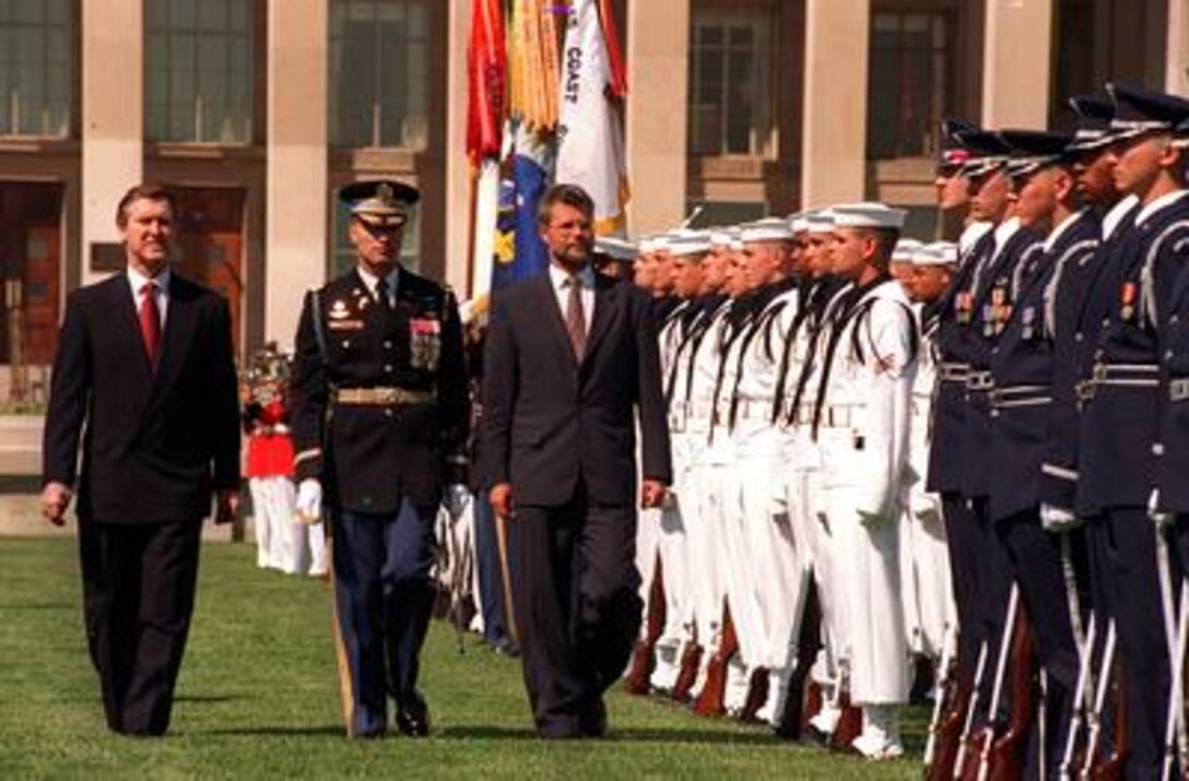 Secretary of Defense William Cohen (left) and Col. David H. Huntoon, U.S. Army, commander of troops (center), escort visiting Danish Defense Minister Hans Haekkerup as he inspects the joint service honor guard during ceremonies welcoming him to the Pentagon, April 30, 1997. Later the two defense leaders met to discuss a range of security issues of interest to both nations. 