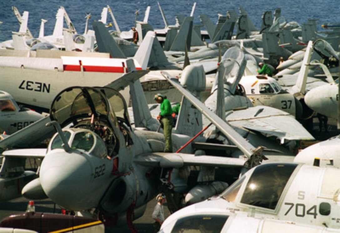 Petty Officer 1st Class Thomas E. Stoneham performs maintenance on a EA-6B Prowler parked on the crowded flight deck of the USS Constellation (CV 64) in the central Pacific Ocean on April 10, 1997. The USS Constellation battle group is en route to the Persian Gulf to enforce no-fly zones and monitor shipping to and from the region. Stoneham is an Aviation Electrician's Mate assigned to Tactical Electronic Warfare Squadron 131, Naval Air Station Whidbey Island, Wash. 