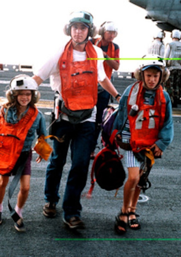 Evacuees from Freetown, Sierra Leone, are rushed across the flight deck of the USS Kearsarge (LHD 3), on May 30, 1997, during Operation Noble Obelisk. Over 900 people from 40 different countries have been evacuated. 